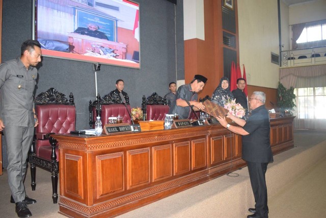 Bupati Kuningan, H Acep Purnama SH MH saat menyerahkan nota pengantar raperda kepada Ketua DPRD Kuningan, Nuzul Rachdy SE. (Andri)