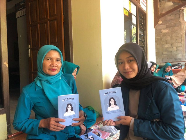 Mahasiswa KKN bersama dengan Ibu ketua RW 01 Kelurahan Cepoko memegang buku panduan KESDIRI (Sumber : Foto Pribadi)