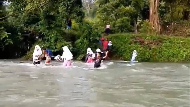 Pelajar di Kabupaten Buru, Maluku, harus lewati sungai deras untuk ke sekolah. Foto: Dok. Istimewa