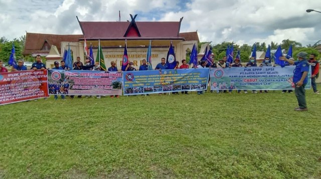 Sejumlah buruh yang tergabung dalam Konfederasi Serikat Pekerja Seluruh Indonesia (KSPSI) kabupaten Kotawaringin Barat membentangkan spanduk penolakan terhadap UU Cipta Kerja yang dinilai banyak merugikan para pekerja. Foto: IST/InfoPBUN