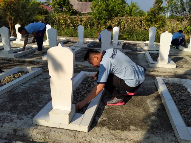 Staf KPLP, Lutfi Anggara Mencabut Rumput pada Salah Satu Makam (Humas Lastagung)