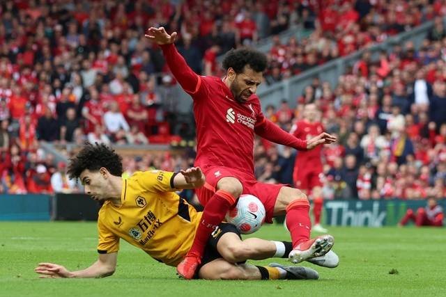 Pemain Liverpool Mohamed Salah beraksi dengan pemain Wolverhampton Wanderers Rayan Ait-Nouri di Stadion Anfield, Liverpool, Inggris, Minggu (22/5/2022). Foto: Phil Noble/REUTERS