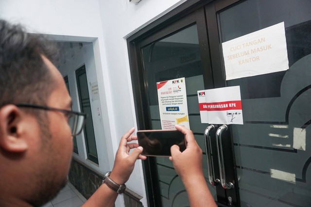 Seorang wartawan memotret pintu salah satu ruangan Dinas Kominfo Kabupaten Pemalang yang telah disegel oleh KPK di Pemda Kabupaten Pemalang, Jawa Tengah, Kamis (11/8/2022). Foto: Harviyan Perdana Putra/Antara Foto