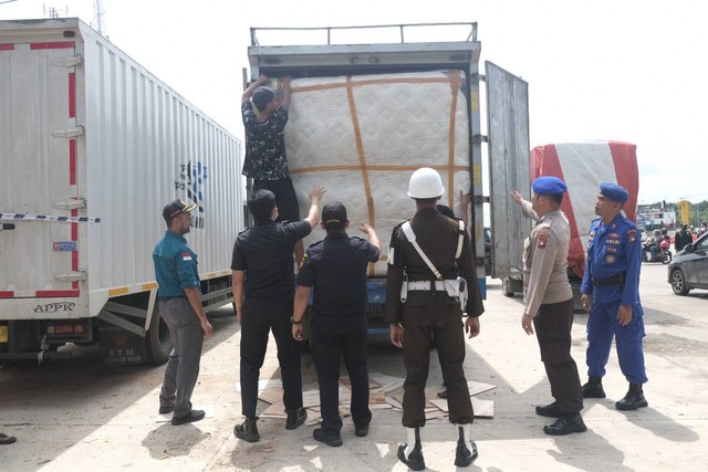 Petugas gabungan memeriksa truk angkutan barang yang baru saja tiba di pelabuhan Telaga Punggur, Batam dari Sumatra. Foto: 