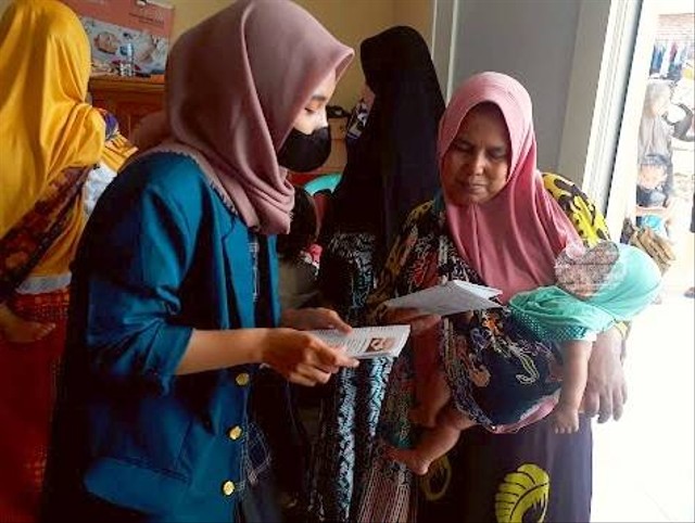 Mahasiswi KKN UNDIP menjelaskan materi edukasi tatalaksana penanganan demam kepada seorang ibu di posyandu RW 02 Mayangsari, Kalipancur. (Sumber: Dokumentasi Pribadi)