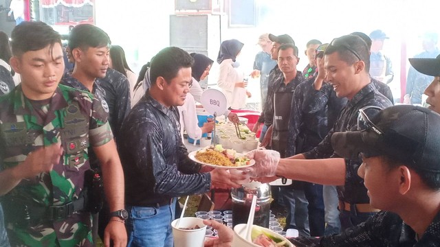Komandan Batalyon 22 Manggala Yudha Kopassus, Mayor Inf Abraham Pandjaitan, menyerahkan masakan kepada anggota Kopassus di Markas Grup 2 Kopassus Kandang Menjangan, Kartasura, Sukoharjo. FOTO: Agung Santoso