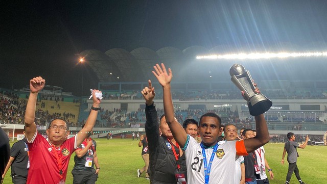 Pemain Timnas U-16 Indonesia, Iqbal Gwijangge (kanan), membawa trofi Piala AFF U-16 2022. Foto: Soni Insan Bagus L/kumparan