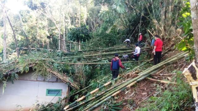 Petugas BPBD Sumedang membersihkan batang pohon bambu yang menimpa rumah warga di Dusun Giriharja RT 06/03, Desa Ciherang, pada Sabtu (13/8/2022). Foto: Diskominfo Sumedang