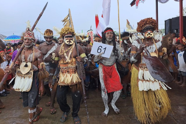 Sejumlah warga Suku Asmat mengenakan pakaian tradisional mengikuti karnaval budaya di Lapangan Yos Sudarso, Agats, Asmat, Papua Selatan, Senin (15/8/2022). Foto: Abdel Syah/Antara Foto