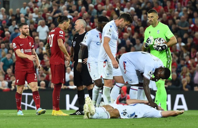 Pemain Crystal Palace Joachim Andersen terjatuh setelah mengalami cedera usai duel dengan pemain Liverpool Darwin Nunez. Foto: Peter Powell/Reuters