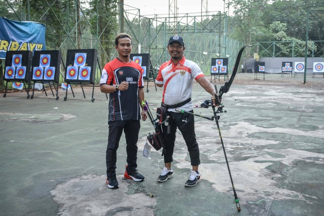 Kholidin alias Bang Udin (kanan), atlet parapanahan yang raih medali ASEAN Para Games 2022, berlatih panahan bersama Coach Denny Decko di Felfest Universitas Indonesia Depok, Jawa Barat, pada Agustus 2022. Foto: Alif Zaky Assidiqi/kumparan