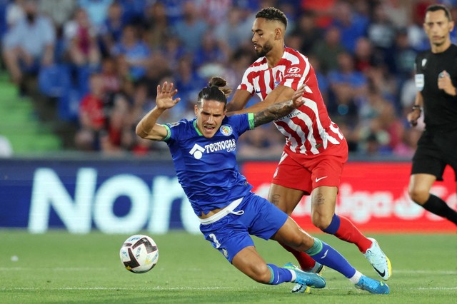 Gelandang Getafe Spanyol Jaime Seoane (kiri) bersaing dengan bek Atletico Madrid Brasil Renan Lodi selama pertandingan sepak bola liga Spanyol antara Getafe CF dan Club Atletico de Madrid di stadion Alfonso Perez Coliseum di Getafe. Foto: Thomas Coex/AFP