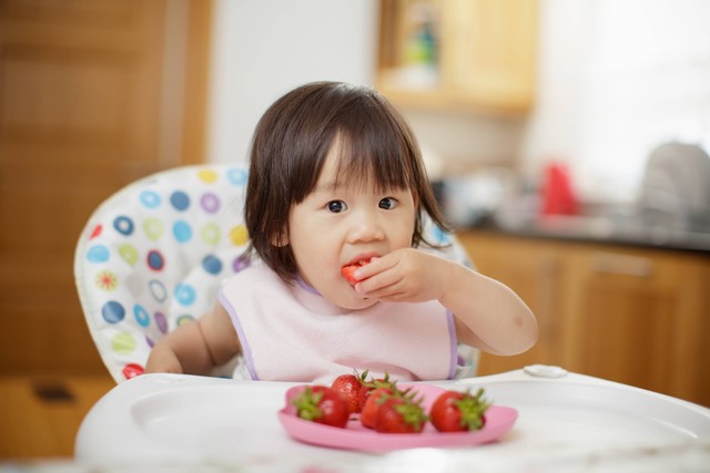 Ilustrasi bayi makan stroberi.  Foto: Mcimage/Shutterstock