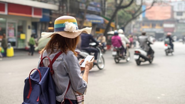 Ilustrasi traveler yang traveling di perkotaan sambil melihat smartphone. Foto: kitzcorner/Shutterstock