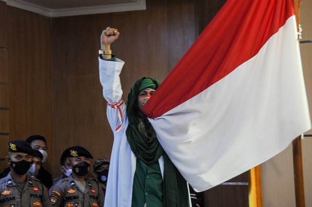 Terdakwa kasus dugaan penyebaran berita bohong Bahar Bin Smith mencium bendera merah putih saat menjalani sidang lanjutan dengan agenda pembacaan putusan di Pengadilan Negeri Bandung, Jawa Barat, Selasa (16/8/2022). Foto: Raisan Al Farisi/ANTARA FOTO