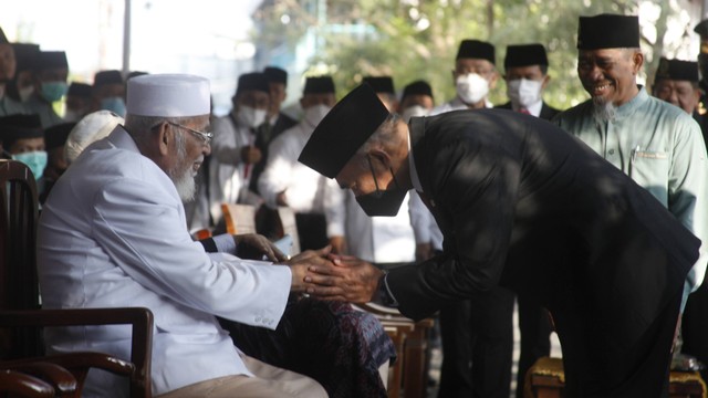Menko PMK Muhadjir Effendy (kanan) bersalaman dengan pendiri Pondok Pesantren Islam Al Mukmin Ngruki Abu Bakar Ba'asyir (kiri) saat upacara HUT Kemerdekaan ke-77 RI di ponpes setempat, Ngruki, Sukoharjo, Jawa Tengah, Rabu (17/8). Foto: ANTARA FOTO/Maulana Surya