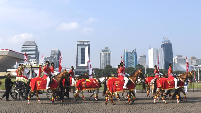 Sejumlah anggota Paspampres mengendarai Kereta Kencana Ki Jaga Raksa yang membawa duplikat Bendera Pusaka Merah Putih dan Teks Proklamasi ketika Parade Kirab Bendera Pusaka dari Monas menuju Istana Merdeka di Jakarta, Rabu (17/8). Foto: ANTARA FOTO/Hafidz Mubarak A