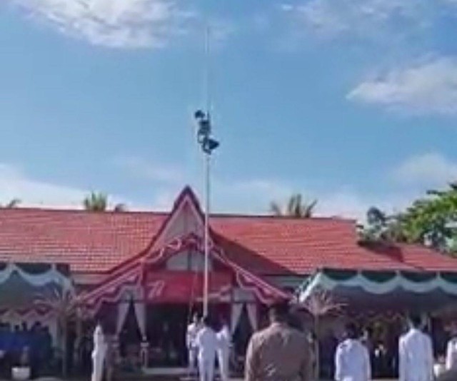 Rajili saat memanjat tiang bendera, untuk mengambil tali kerek yang terlepas, pada peringatan HUT kemerdekaan di Kantor Kecamatan Semparuk, Sambas. Foto: Dok Hi!Pontianak