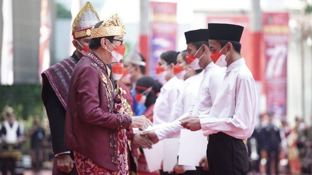 Menkum HAM, Yasonna Laoly, memberikan remisi secara simbolis kepada beberapa warga binaan pemasyarakatan di lapangan Kemenkumham. (Foto: Kemenkumham)