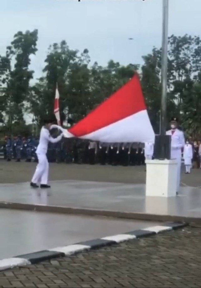 paskibraka bernama Muhammad Tegar Vanesha melakukan manuver agar bendera Merah Putih membentang sempurna di Halaman Kantor Bupati Kubu Raya, Kalbar. Foto: Dok Hi!Pontianak