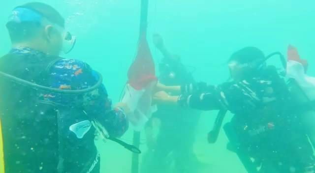 Pengibaran bendera merah putih di dasar laut perairan Pulau Lemukutan. Foto: Dok. Istimewa