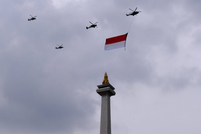 Helikopter TNI/Polri melakukan terbang formasi dengan membawa Bendera Merah Putih di langit kawasan Monas saat Upacara Peringatan Detik-Detik Proklamasi pada perayaan HUT ke-77 RI di Jakarta, Rabu (17/8/2022).  Foto: Hafidz Mubarak A/ANTARA FOTO