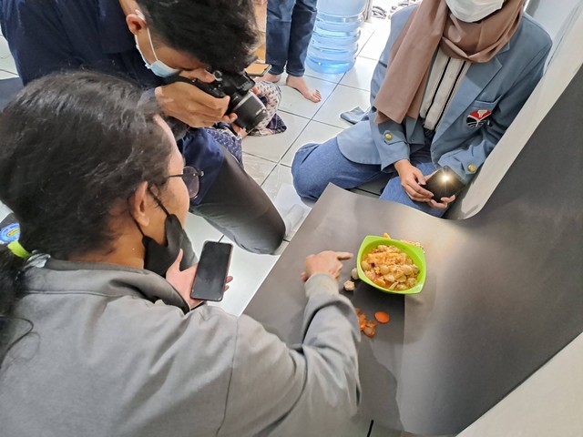 Mahasiswa KKN Tematik UPI Kelompok 57 Sindangjaya sedang melakukan pengambilan gambar produk UMKM menggunakan kamera DSLR (Dokumentasi Pribadi)