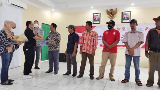 (kanan) Kepala Desa Batu Belaman Rudi Hartono menerima piagam penghargaan dan uang pembinaan dari Chief Operating Officer PT SSMS, Tbk Muhammad Syafril Harahap. Foto: Lukman Hakim/InfoPBUN