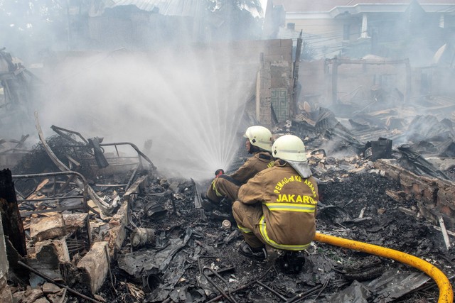 Petugas pemadam kebakaran memadamkan api yang membakar rumah penduduk di kawasan Jalan Simprug Golf Dua, Jakarta, Minggu (21/8/2022). Foto: Muhammad Adimaja/Antara Foto