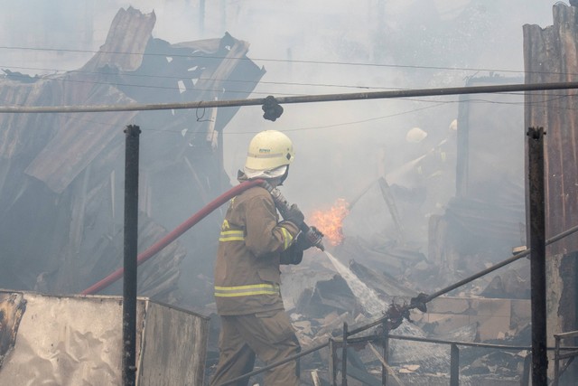 Petugas pemadam kebakaran memadamkan api yang membakar rumah penduduk di kawasan Jalan Simprug Golf Dua, Jakarta, Minggu (21/8/2022). Foto: Muhammad Adimaja/Antara Foto