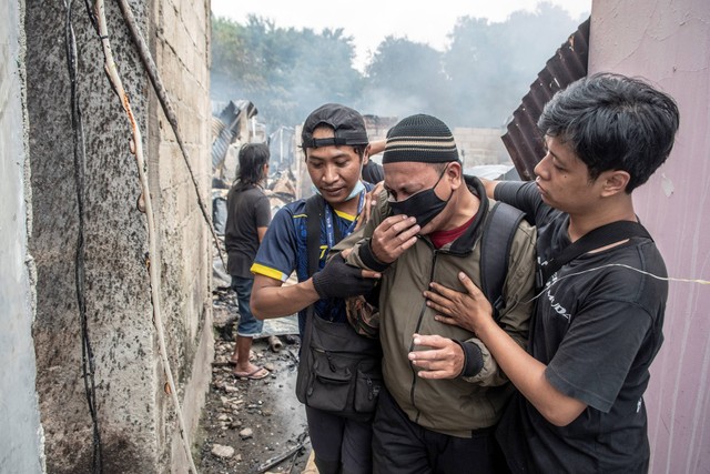 Warga menangis saat melihat kondisi rumahnya yang terbakar di kawasan Jalan Simprug Golf Dua, Jakarta, Minggu (21/8/2022). Foto: Muhammad Adimaja/Antara Foto