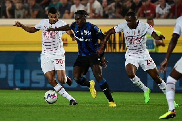 Pemain Atalanta Duvan Zapata berusaha melewati dua pemain AC Milan pada pertandingan lanjutan Liga Italia di Stadion Atleti Azzurri, Bergamo, Italia. Foto: Miguel MEDINA / AFP