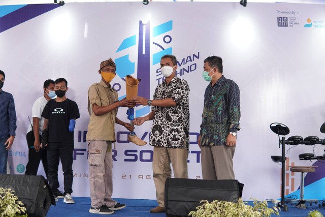 Kang Iwan menerima lutut prostetik dari Dosen Teknik Mesin ITB, Sandro Mihradi pada "Salman Techno Fest", Minggu, 21 Agustus 2022. (Dok. Rumah Amal Salman) 