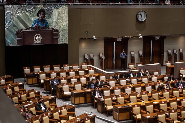 Sejumlah anggota DPR menyimak pidato Menteri Keuangan Sri Mulyani (dalam layar) pada rapat paripurna DPR di kompleks Parlemen, Senayan, Jakarta, Selasa (23/8/2022). Foto: Aprillio Akbar/Antara Foto