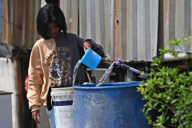 Warga memanfaatkan air bersih dari Perumda Perusahaan Air Minum (PAM) Jaya untuk mencuci pakaian di RW 01, Kamal Muara, Jakarta, Selasa (23/8/2022). Foto: Aditya Pradana Putra/Antara Foto