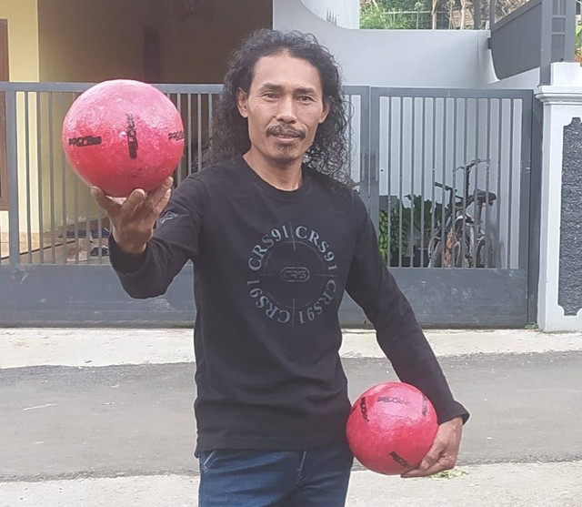 Pelaku UMKM bola sepak, Roja’i memegang produk bola berbahan baku limbah plastik kresek. (Bentar/Panturapost)