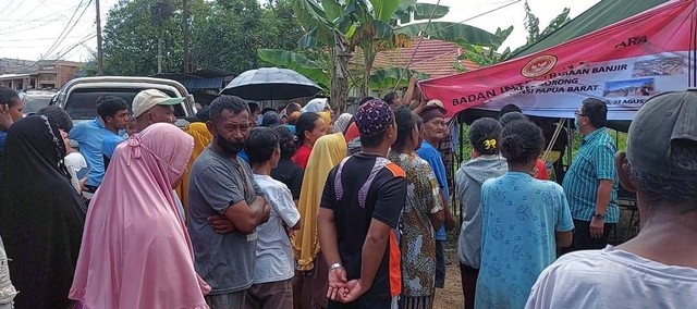 Tampak masyarakat korban banjir tengah antri menerima bantuan dari BIN.