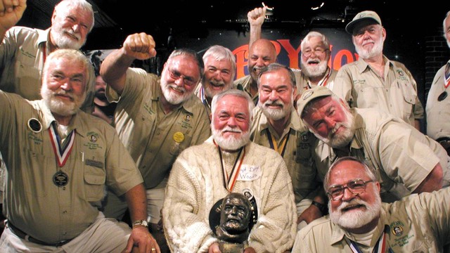 Dikelilingi oleh pemenang sebelumnya, Denny Woods (tengah) dari Buckeye Lake, Ohio, membuai patung Ernest Hemingway 21 Juli 2001, tepat setelah ia mengalahkan 117 kontestan lain di Kontes Serupa Hemingway "Papa" di Sloppy Joe's Bar di Key Barat, FL.  Foto: Andy Newman/AFP