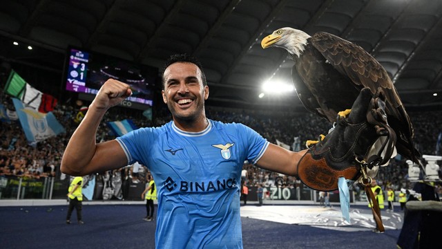 Pemain Lazio Pedro melakukan selebrasi dengan maskot Olympia setelah pertandingan di Stadio Olimpico, Roma, Italia, Jumat (26/8/2022). Foto: Alberto Lingria/REUTERS