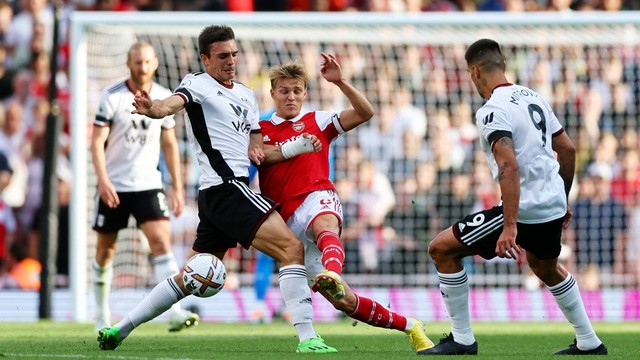 Pemain Arsenal Martin Odegaard beraksi dengan pemain Fulham Joao Palhinha dan Aleksandar Mitrovic di Stadion Emirates, London, Inggris, Sabtu (27/8/2022). Foto: David Klein/REUTERS