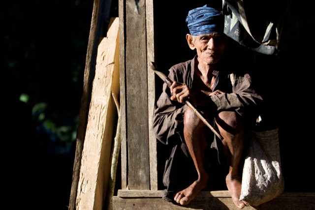 Seorang pria suku Baduy duduk di rumahnya, di kawasan hutan perbukitan pegunungan Kendeng, Banten. Foto: Ulet Ifansasti/Getty Images