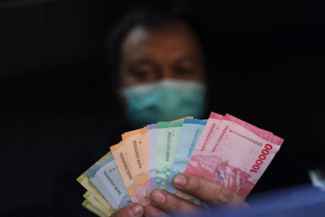 Warga menunjukkan uang rupiah kertas Tahun Emisi 2022 di Pasar Senen, Jakarta Pusat, Senin (29/8/2022). Foto: Iqbal Firdaus/kumparan
