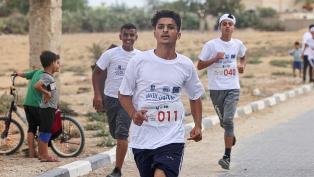 Pemuda Palestina berkompetisi dalam Marathon Al-Amal (Harapan) di Khan Yunis di Jalur Gaza selatan, pada Senin (28/8/2022). Foto: Said Khatib/AFP