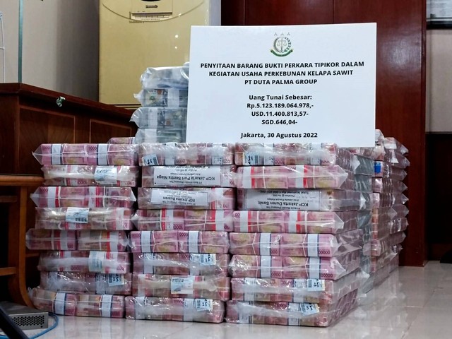 Tumpukan uang sitaan dalam pecahan rupiah dan mata uang asing tersangka pemilik PT Duta Palma Group, Surya Darmadi yang diekspose Kejagung, Selasa (30/8/2022). Foto: Hedi/kumparan