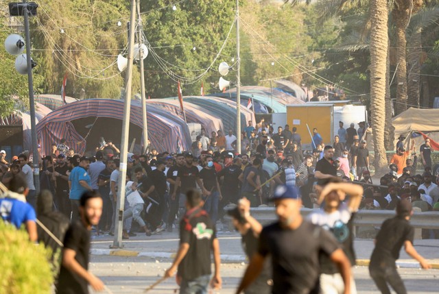 Pendukung pemimpin populis Irak Moqtada al-Sadr bentrok dengan pendukung Kerangka Koordinasi, sekelompok partai Syiah, di Zona Hijau di Baghdad, Irak, Senin (29/8/2022). Foto: Thaier Al-Sudani/Reuters