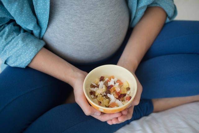 Ilustrasi ibu hamil makan buah kering. Foto: Tanya Yatsenko/Shutterstock