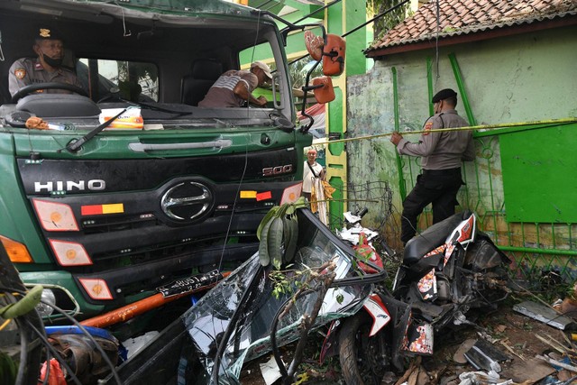 Petugas Kepolisian berusaha mengevakuasi sebuah truk kontainer yang menabrak halte bus di depan SDN Kota Baru II dan III di Jalan Sultan Agung, Bekasi, Jawa Barat, Rabu (31/8/2022). Foto: Fakhri Hermansyah/ANTARA FOTO