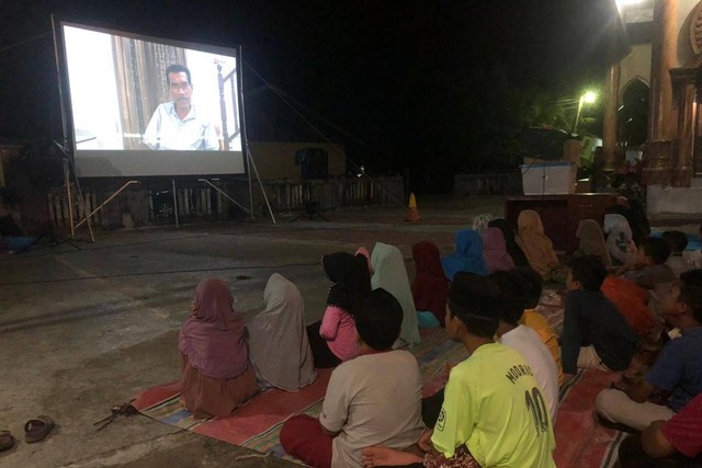 Anak-anak di Ujong Tanjong, Kecamatan Meureubo, Aceh Barat, menyaksikan layar tancap Aceh Film Festival 2022 program Gampong Film, Sabtu (4/9) malam. Foto: Siti Aisyah/acehkini