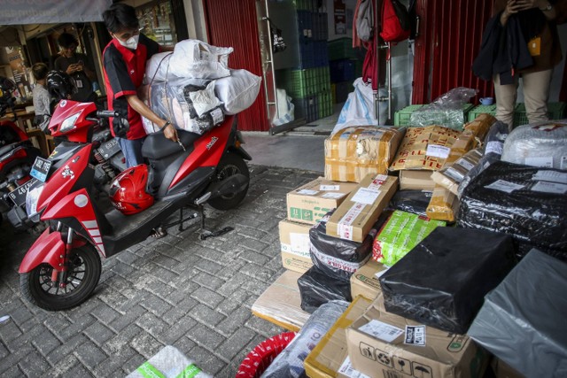 Kurir ekspedisi bersiap mengantarkan barang menggunakan motor listrik di Jakarta, Senin (5/9/2022). Foto: Rivan Awal Lingga/Antara Foto