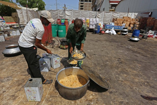 Sejumlah pekerja 'Saylani Welfare Trust' memasak makanan untuk warga yang terkena dampak banjir di Hyderabad, Sindh, Pakistan, Senin (5/9/2022). Foto: Akram Shahid/AFP
